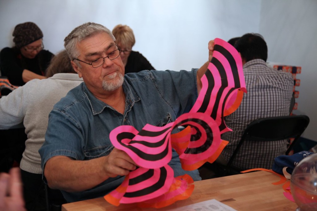 Workshop participant with a mathematically correct model of a hyperbolic plane. The black and pink consecutive rings highlight the gradual expansion of the hyperbolic space.