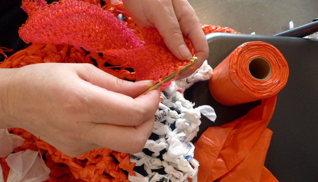 Christine Wertheim crochet's orange plastic bags.