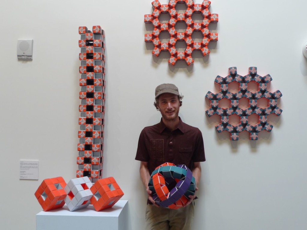 Jesse Dotson with his hexagonal tiling structures and his "armillary sphere". At left is David Orozco's tower and three linked Level One Menger Sponge fractals by Margaret Wertheim.