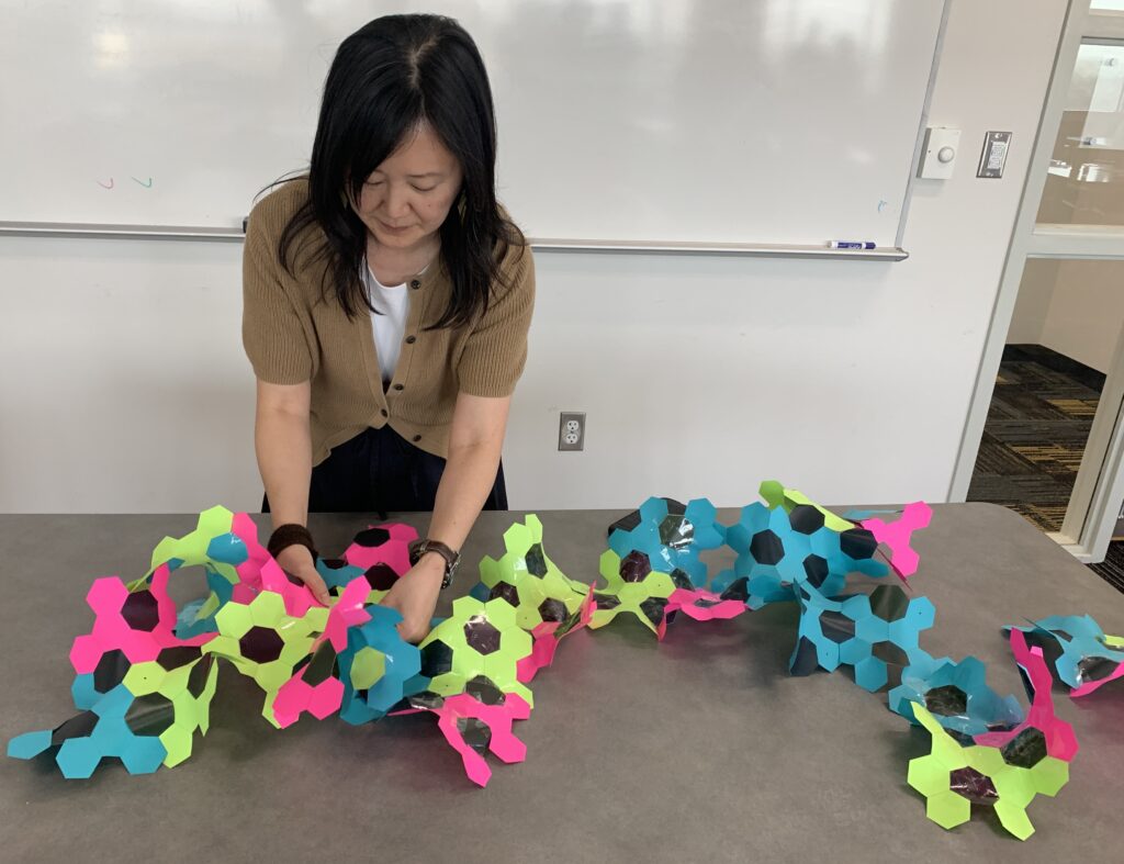 person with paper model of hyperbolic space